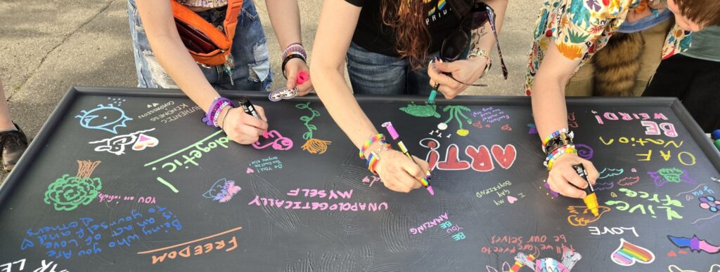 Young people drawing art on a black canvas.