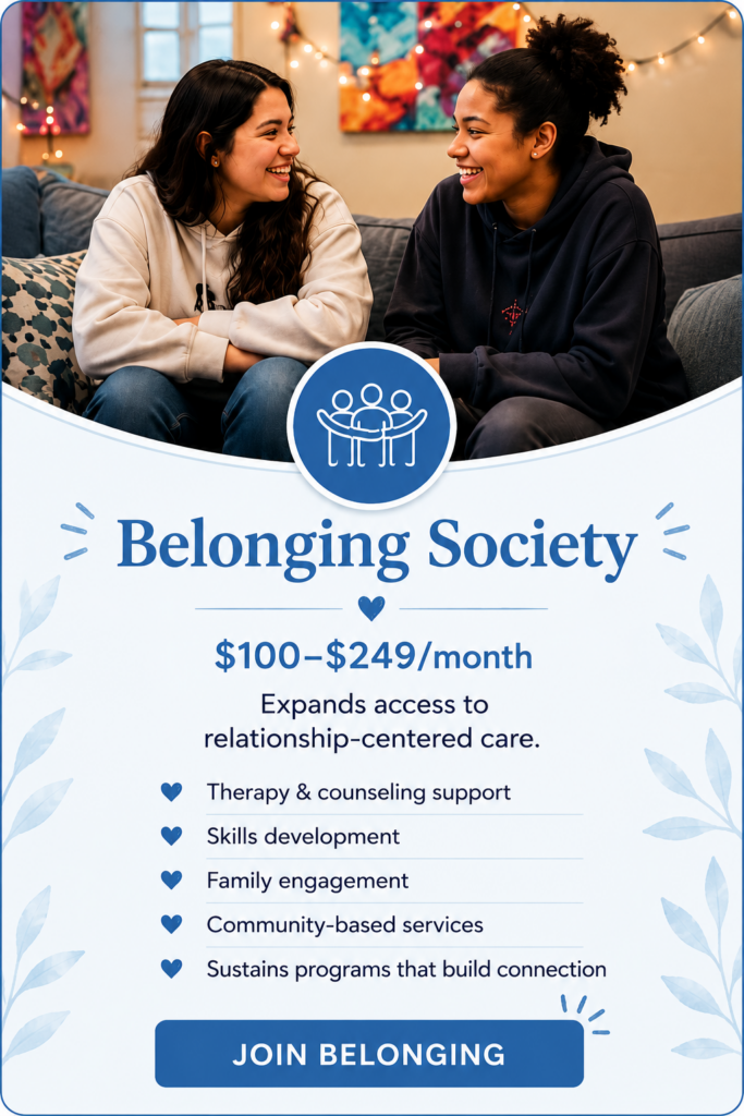 Two young people share a warm conversation and smile together, representing the Belonging Society and the connection, trust, and relationship-centered support that help young people thrive.